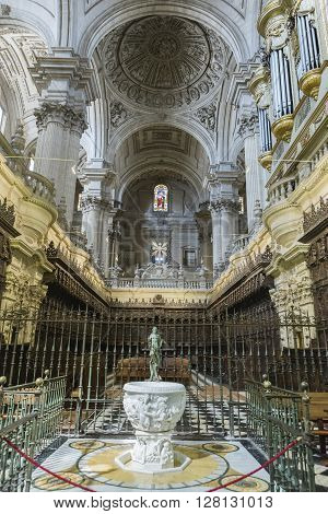 Jaen, Spain - may 2 2016: View of the entrance to the choir, one of the largest in Spain, stack baustismal of white marble of Carrara with a statue of Jesus risen made in bronze, completed in the 18th century, Spain
