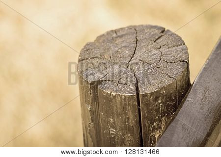 part of an old column from a wooden fence for the ranch closeup on an indistinct background of color sepia