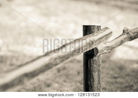 part of an old column and poles from a wooden fence for the ranch closeup on an indistinct background of beige color