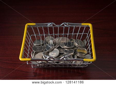 Many one dirham coins in a shopping basket - A concept