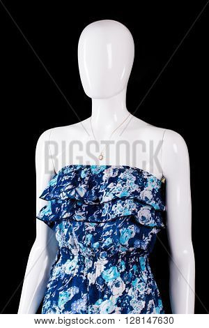 Blue dress and small pendant. Mannequin wearing pendant and dress. Summer dress on dark background. Handmade garment in workshop.