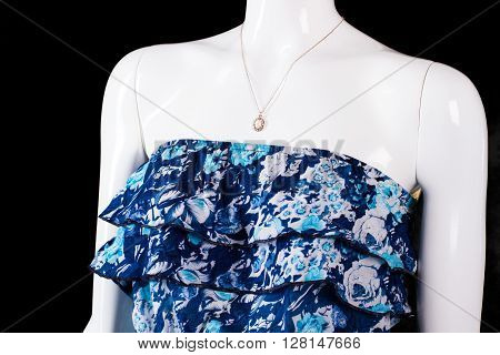 Strapless blue dress and pendant. Small necklace on white mannequin. Woman's custom made accessory. Merchandise worth its price.