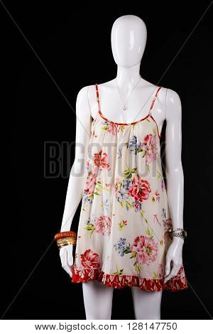 Casual sarafan with floral pattern. White mannequin in floral sarafan. Light sarafan on dark background. Lady's new clothes for summer.