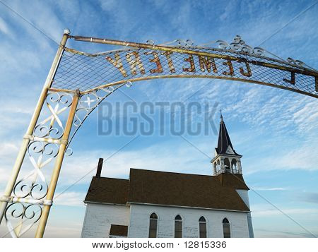 Metal cemetary entryway with small church.