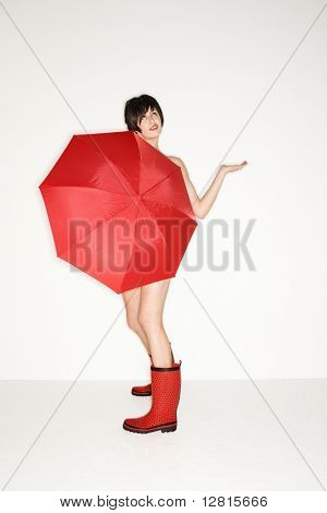 หญิงสาวเซ็กซี่ Caucasian สีแดงรองเท้าถือร่มสีแดง และตรวจสอบฝน