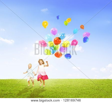 Little Girl and Boy Outdoors Holding Balloons