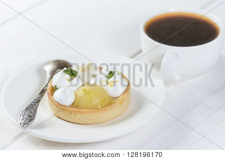 Lemon tart with mint on a plate with coffee
** Note: Shallow depth of field
