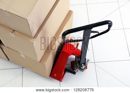Manual pallet truck with carton boxes indoors