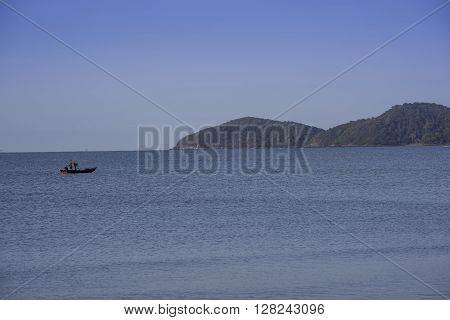 Silhouetted Fishing Boat Showing Misty Mountains Early Morning Sun.