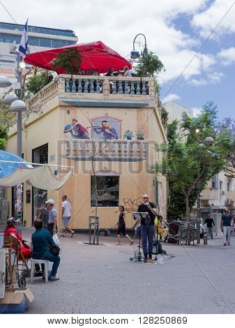 Tel Aviv, Israel - April 28 2016: A street singer in the market square in the old part of the Tel Aviv, Isarel