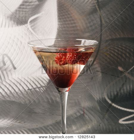 Zátiší martini míchané nápoje s malinovou ovoce agaisnt texturou kovové pozadí.