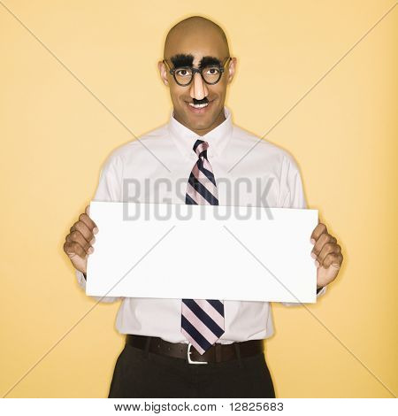 African American man wearing groucho mask disguise holding blank sign.
