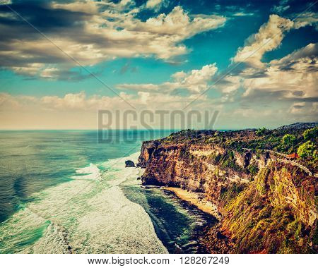 Vintage retro effect filtered hipster style image of Uluwatu cliff in ocean on sunset. Bali, Indonesia