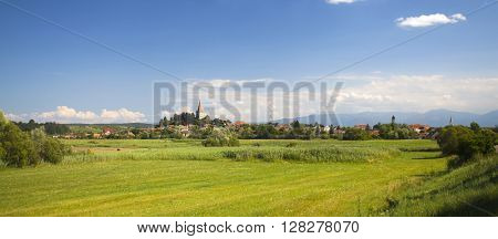 Idyllic rural view of gently rolling patchwork farmland and village in the summer