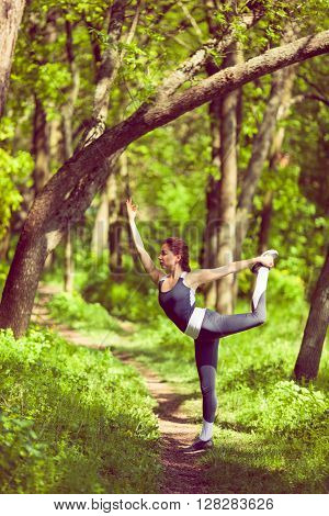 Young girl doing yoga in the park