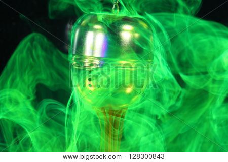 A tea ball with fluorescein in water. Fluorescein is a green fluorescent coloring agent for water.