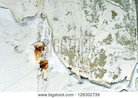 Rust patch and peeling paint on wall