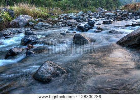 Beautiful Reshi River water flowing through stones and rocks at dawn Sikkim India. Reshi is one of the most famous rivers of Sikkim flowing through the state and serving water to many local people.