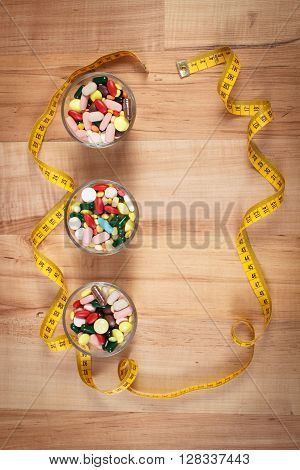 Tape measure and colorful medical pills capsules or supplements for therapy or weight loss concept of treatment health care and slimming copy space for text