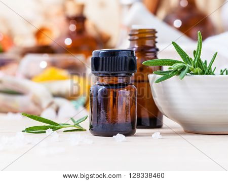 Fresh Rosemary And Essential Oil With Shallow Depth Of Field Setup On Wooden Background .