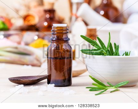 Fresh Rosemary And Essential Oil With Shallow Depth Of Field Setup On Wooden Background .
