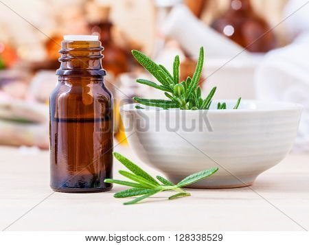 Fresh Rosemary And Essential Oil With Shallow Depth Of Field Setup On Wooden Background .
