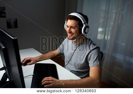 technology, gaming, entertainment, let's play and people concept - happy young man in headset with pc computer playing game at home and streaming playthrough or walkthrough video