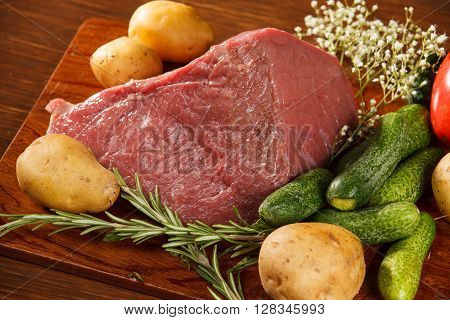 Raw meat with vegetables on a wooden table for a delicious dinner