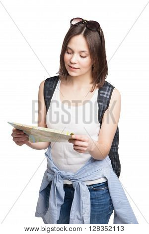 young pretty girl in looking for place on  map with rucksack over white background