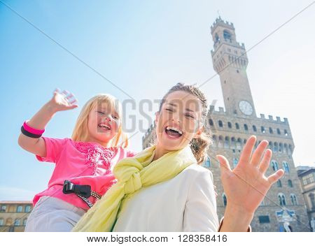 Smiling Mother And Daughter Near Palazzo Vecchio Handwaving