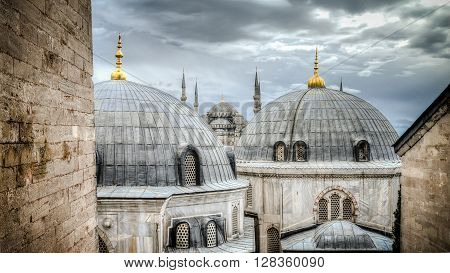 Blue Mosque through the domes of HagiaSophia in Sultanahmet Istanbul Turkey