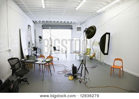 Interni di studio fotografico con luci e varie attrezzature e oggetti di scena.