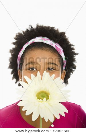 African American girl innehar stora Gerbera Daisy över ansiktet och titta på betraktaren.