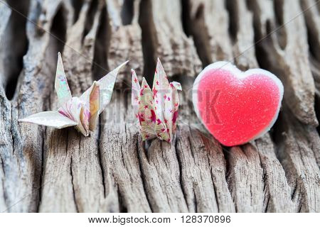 Origami couple paper crane and heart on wood