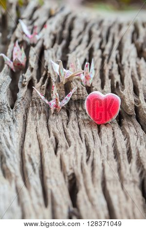 Origami couple paper crane and heart on wood