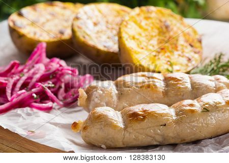 macro meat kupaty with fries and greens on white plate. potato