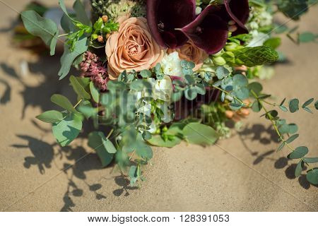 Bride's Pink Orange and White Wedding Bouquet Laying on Sand