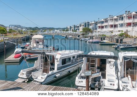 KNYSNA SOUTH AFRICA - MARCH 3 2016: The marina at the historic Thesens Island with luxury homes. Several types of boats including houseboats are visible