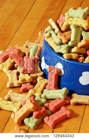 An over abundant supply of various dog treats flowing from a dish.