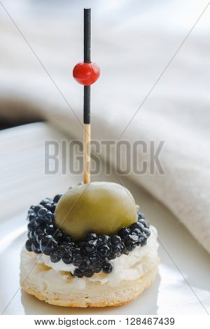 fresh canapes with black caviar on a plate