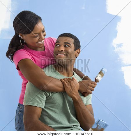 Porträt der Afroamerikaner männliche und weibliche paar neben Hälfte Wand gemalt.