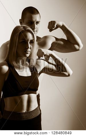 Guy and girl flex biceps. Muscular couple flexing arms. Show me the bicep peak. How to build big arms.