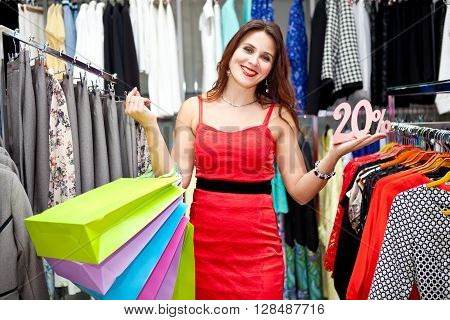 Young woman choosing clothes on a rack in a showroom