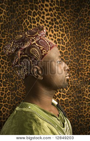 Ritratto di profilo di un uomo afro-americano indossando abiti tradizionali africani, davanti a un patt