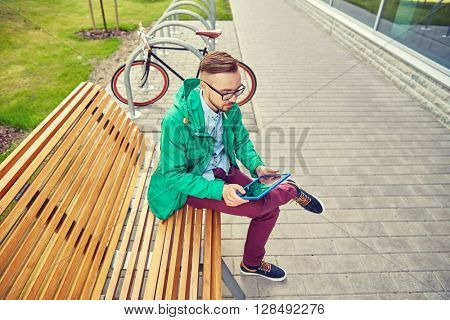 people, style, technology and lifestyle - happy young hipster man with tablet pc computer and fixie bike sitting on bench in city