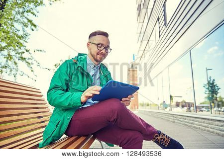people, style, technology and lifestyle - happy young hipster man with tablet pc computer and fixie bike sitting on bench in city