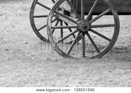 closeup of monochrome tone fragment of the ancient wooden animal-drawn vehicle with spoke wheels