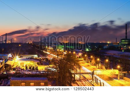 Night landscape with a road in the industrial area of the city and the pipes metallurgical plant on the horizon. View from the top. City Nizhny Tagil. Russia