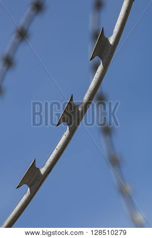 Barbed wire stretched along the brick painted walls