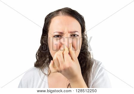 cropped image of a woman covering her nose and mouth with her hands looking at the camera in concept of disgust and there is a bad smell over a white background